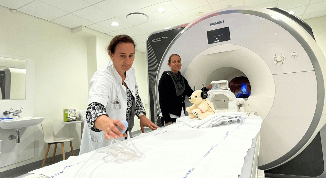 Researcher Melanie Ganz and nurse working with MR scanner