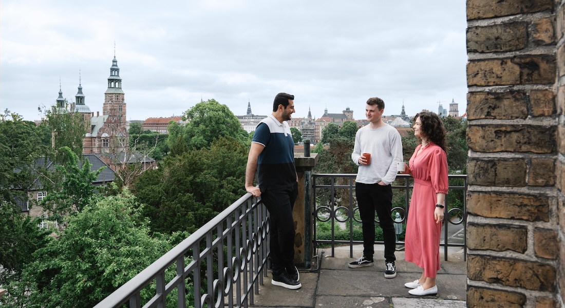 Researchers standing on balcony with Copenhagen city in the background