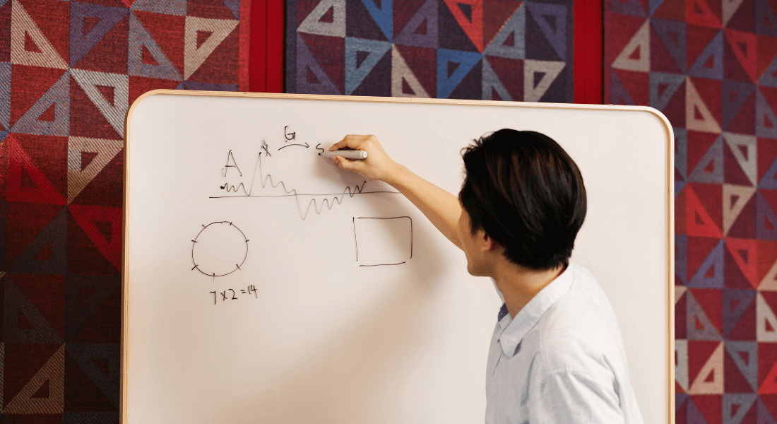 A person writing on a whiteboard