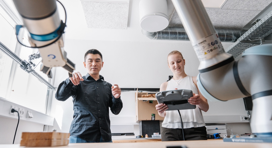 Man and woman working with robotic arms