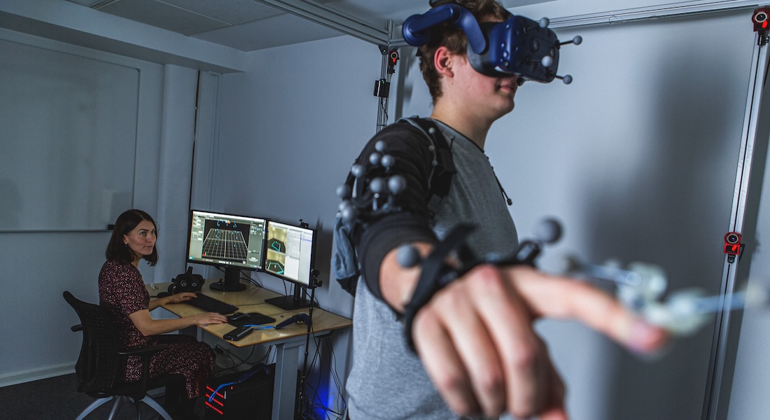 Woman and man in VR lab, man wearing headset and tracking devices